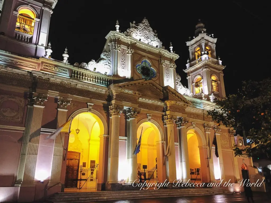 A historic church in Salta, Argentina, illuminated at night, showcasing its intricate architecture, with warm lighting accentuating its features. The city of Salta is known as Salta La Linda for its beautiful plazas and churches. Exploring these areas is one of the best things to do in Salta.