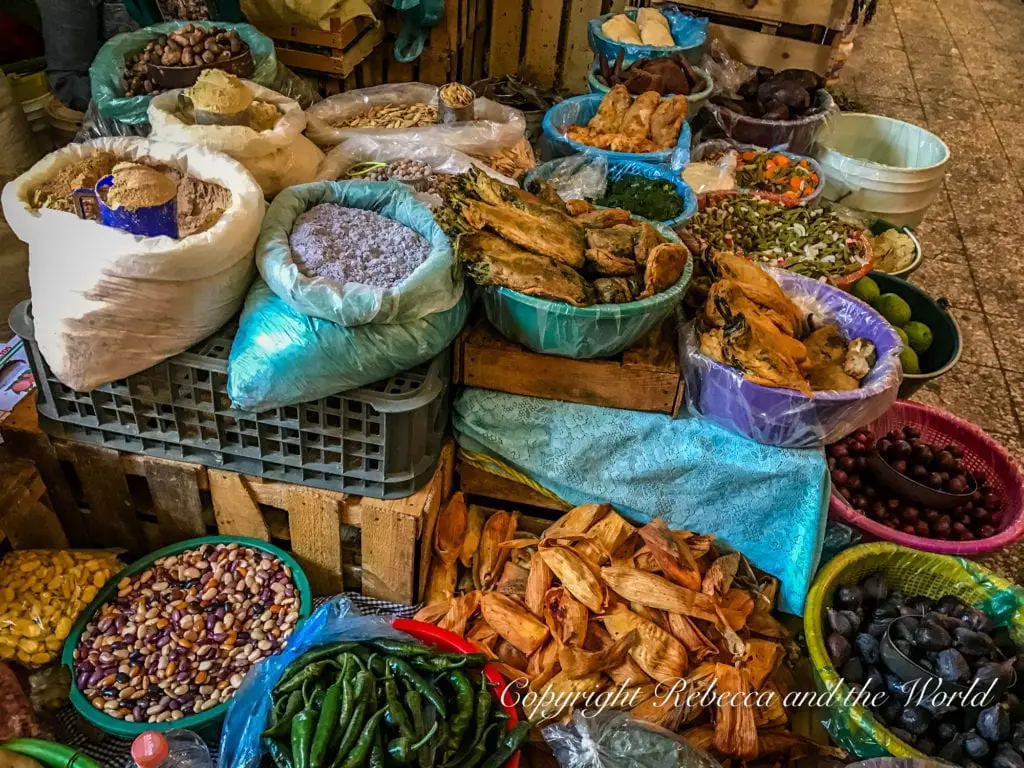 A colorful market stall in Mexico City displaying a variety of goods, including dried chilies, beans, and other traditional Mexican ingredients.