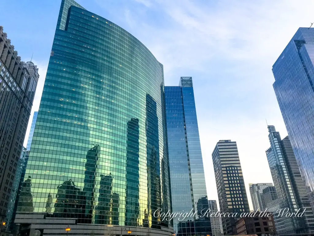 Modern glass skyscrapers reflecting the surrounding buildings and blue sky in downtown Chicago.