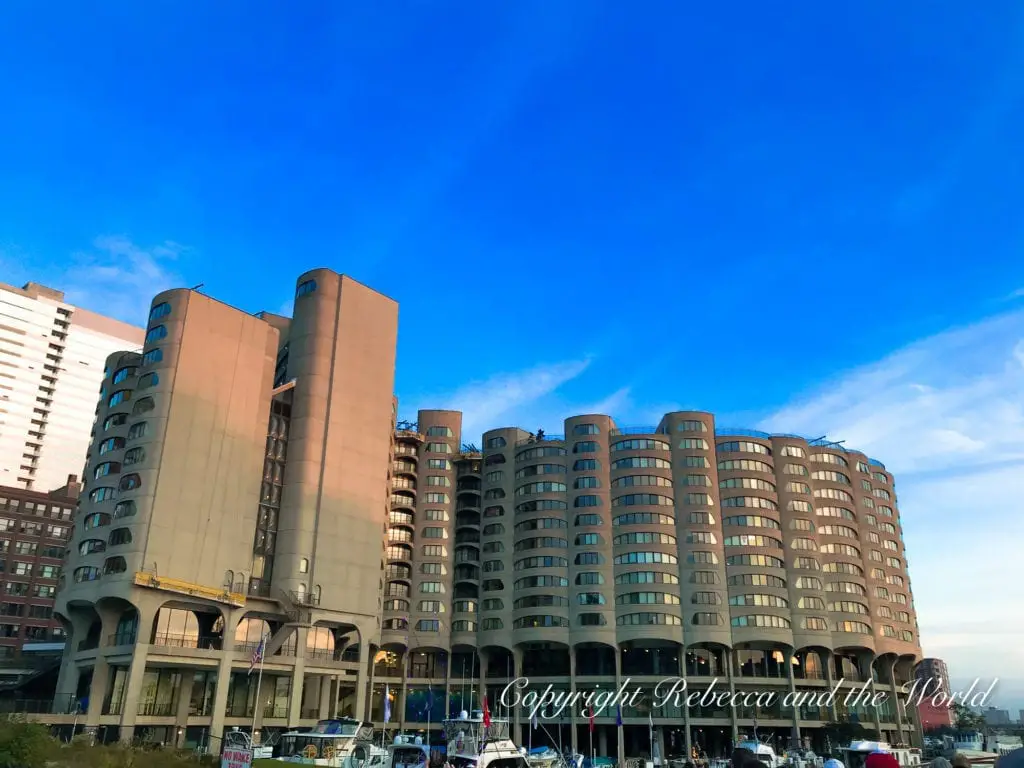 The unique, rounded facade of the River City condominiums with multiple balconies, set against a backdrop of other buildings and a clear sky. One of the best things to do in Chicago is to take a river cruise to see the city's architecture.