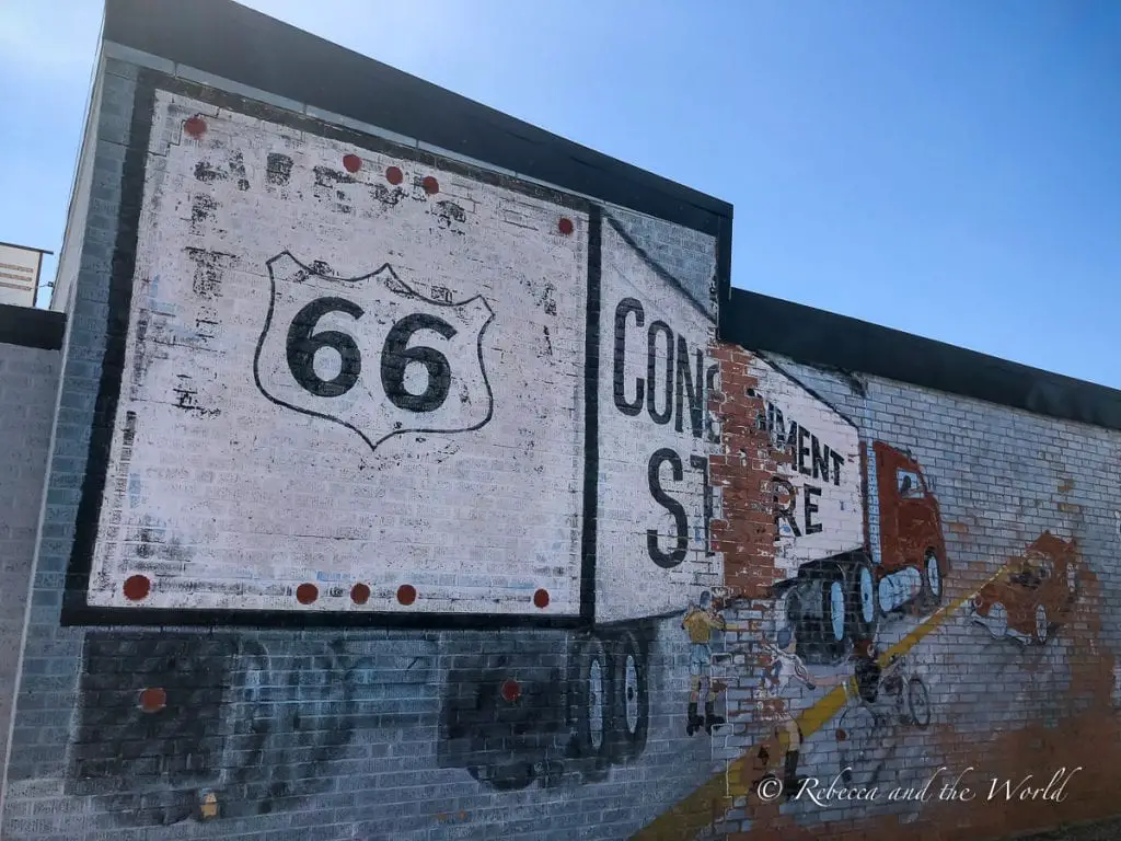 A weathered mural depicting Route 66 sign and a vintage red truck on a brick wall, symbolising the historic highway that passes through Amarillo. Amarillo is one of the most important towns in Texas that historic Route 66 ran through.