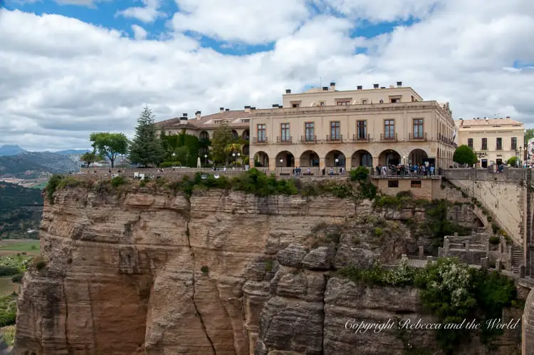 The Parador de Ronda, situated atop a precipice, overlooking a deep gorge, with a terrace offering breathtaking views of the surrounding landscape, characteristic of Ronda's spectacular geography.