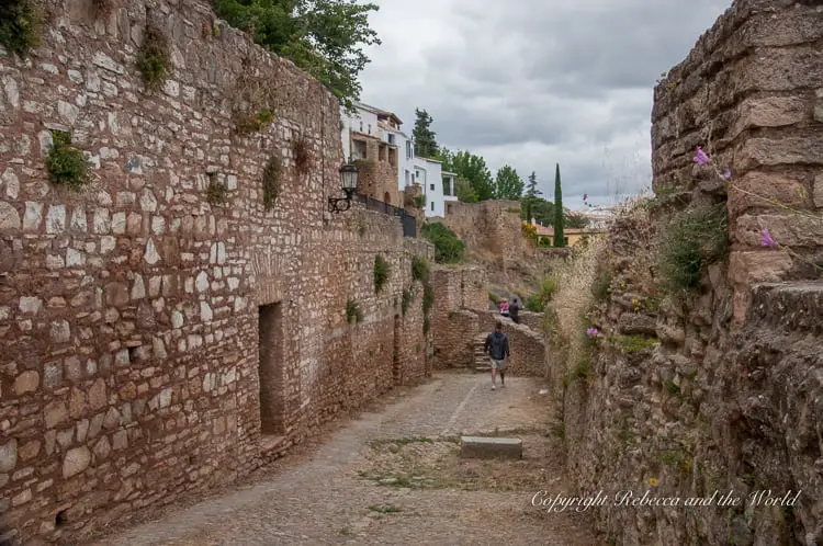 A cobblestone street in Ronda flanked by traditional white houses, inviting a walk through the town's picturesque and historic streets.