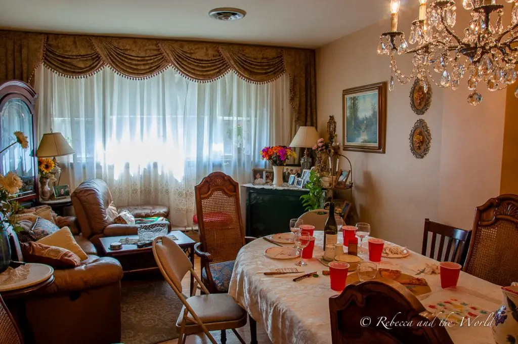 A cozy living room and dining area with a laid table, sofas, flowers, and a chandelier. The Politically Incorrect Boston Food Tour ends with lunch in the tour guide's house - now that's unique!