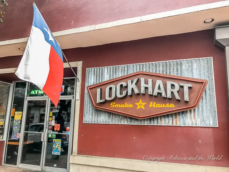 The entrance to 'Lockhart Smoke House' with a Texas flag beside it. There's so much good food to enjoy on a weekend trip to Dallas.