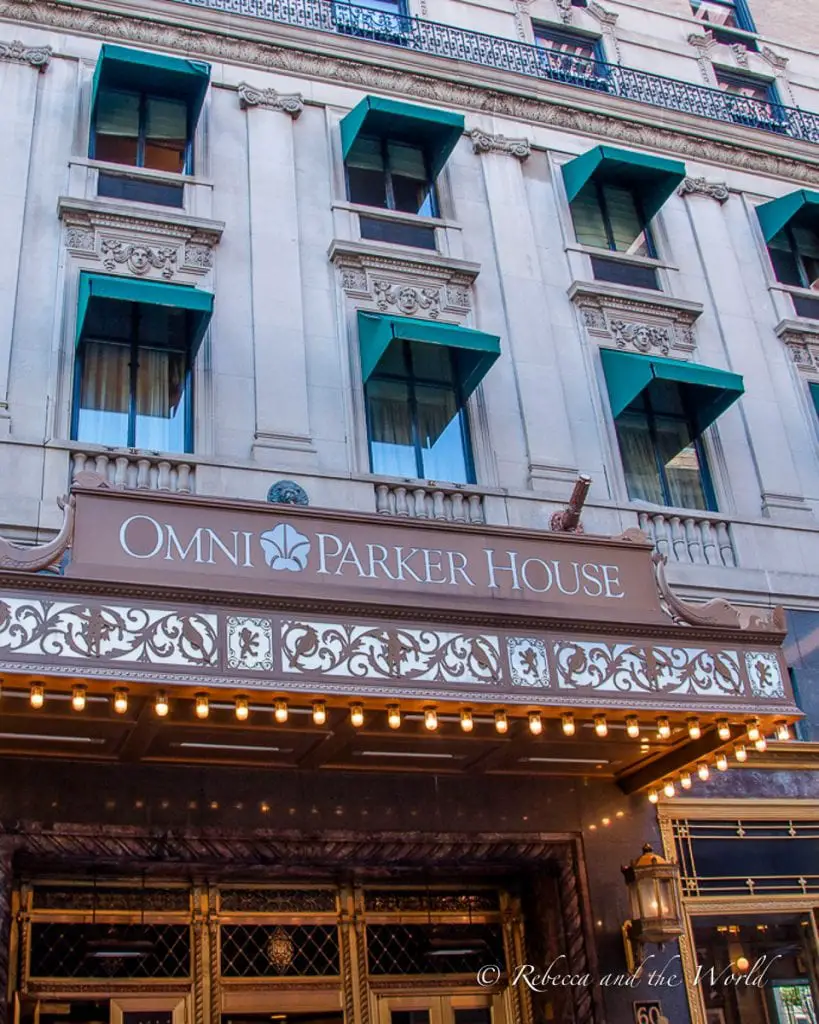 The ornate facade of the Omni Parker House with its elegant signage, illuminated by soft lighting. Head to the Omni Parker House Hotel for the original Boston cream pie.