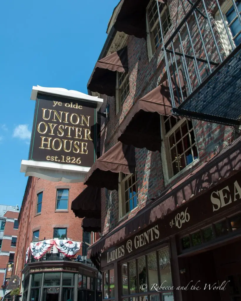 The exterior of the historic Union Oyster House with its iconic sign, established in 1826, against a clear blue sky. Union Oyster House is the oldest operating restaurant in the United States.