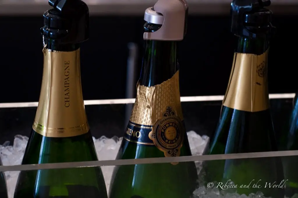 Bottles of champagne chilling in an ice bucket, focused on the gold foil and labels. Sigh is a wonderful champagne bar in Sonoma.