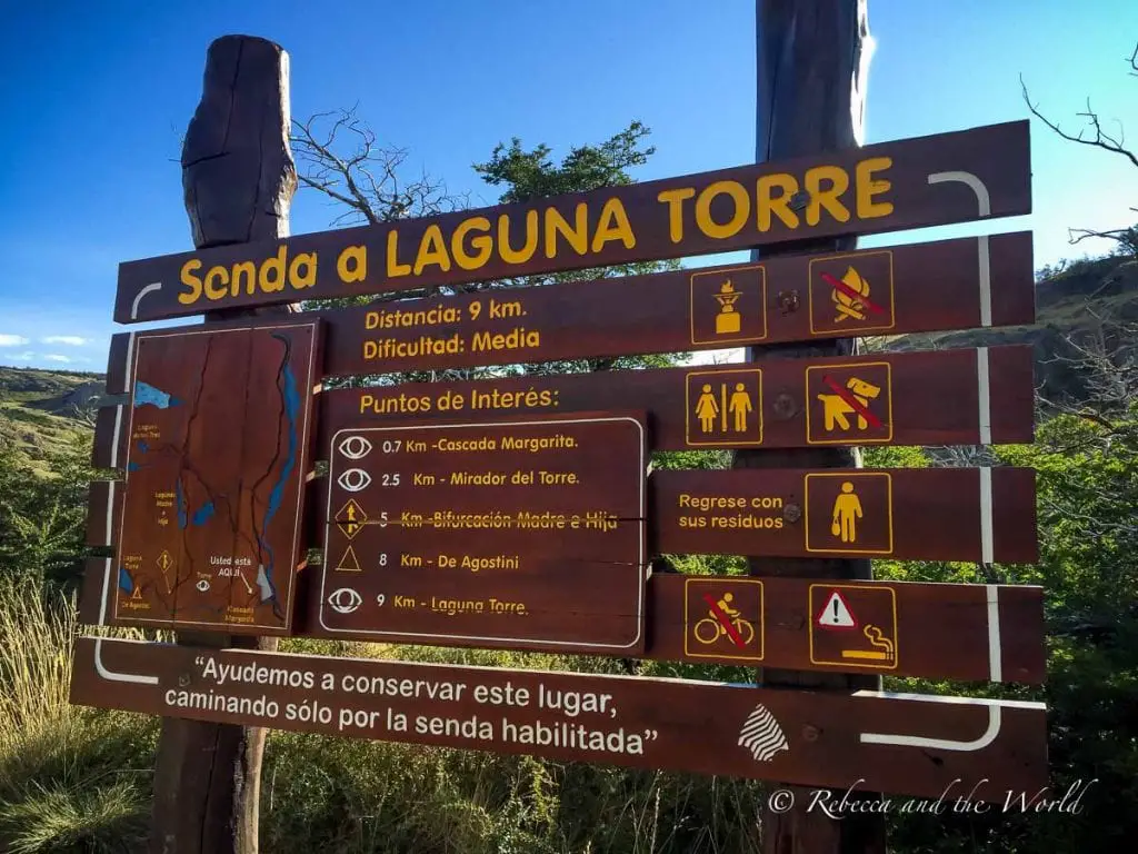 A trail sign providing information for hikers heading to Laguna Torre. The sign details the trail's distance, difficulty level, and points of interest, with various symbols indicating the trail's regulations and guidelines. The Laguna Torre hike in El Chalten is well signed.