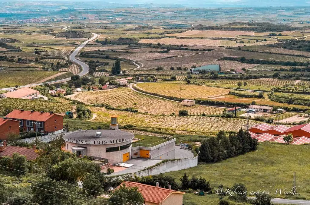 A picturesque view of the rolling hills and vineyards of the La Rioja wine region, showing the rural charm and wine-producing heritage of the region. It's possible to taste wine in Spain's most famous wine region. Taking a day trip to La Rioja wine region is one of the best things to do in Bilbao.