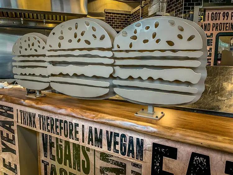 Three-dimensional cutouts of burgers, layered in a staggered fashion, displayed on a countertop with a sign that reads, 'I think therefore I am vegan'. There are so many great places to eat in Atlanta, Georgia.