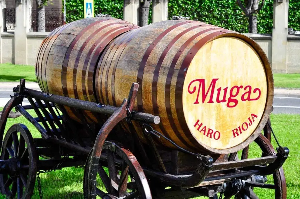 A vintage wooden wine barrel on a cart, labeled "Muga – Haro Rioja," representing the famous Rioja wine produced in the region, a testament to San Sebastian's close proximity to one of Spain's most renowned wine-producing areas. Just a few hours from San Sebastian is the famous wine region of La Rioja, great for a day trip from San Sebastian.