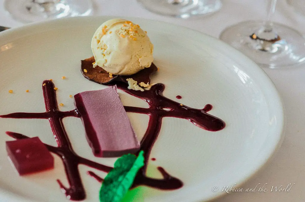 An artistically plated dessert featuring a scoop of vanilla ice cream, a purple jelly slab, and decorative sauces, embodying the fine dining experiences in La Rioja. Dessert at Bodegas Baigorri is to die for, it's one of the great restaurants in La Rioja.