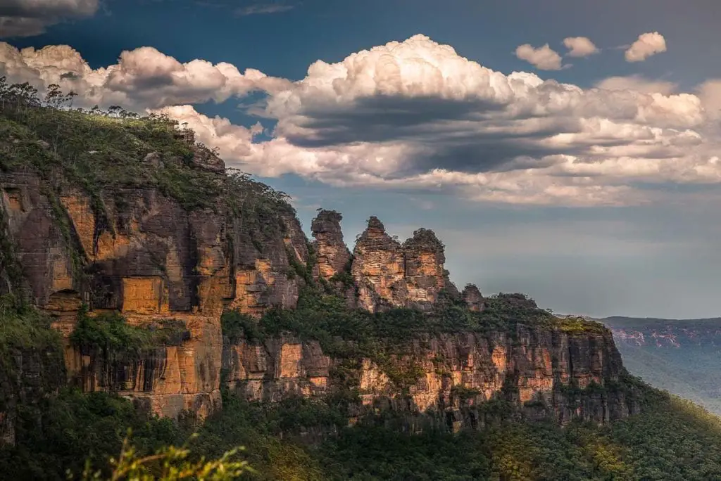 The Three Sisters rock formation in the Blue Mountains, with dramatic cloud formations above. The Blue Mountains are one of the most beautiful places in Australia and is a great weekend getaway from Sydney.