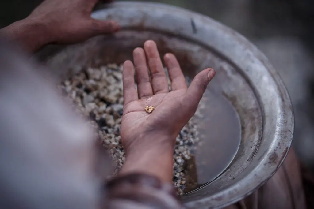 A hand holding a small nugget of gold, illustrating the prospecting and mining part of the Australian experience. You can pan for gold in Ballarat, Victoria - it's one of the best things to do in Australia with kids.