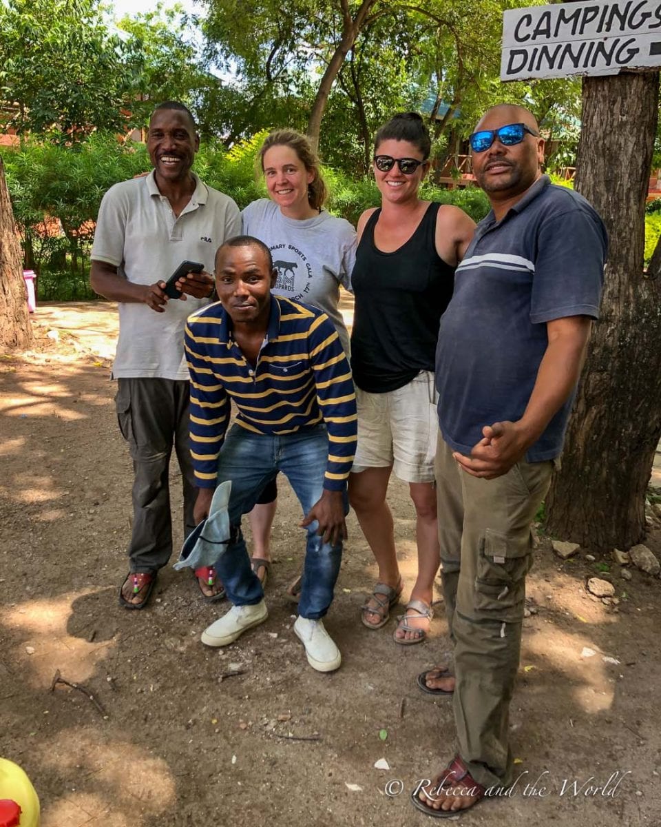 Group photo of five individuals, including three safari guides, smiling and posing together in a campsite. The amazing crew that took care of me during my hike from Ngorongoro to Lake Natron.