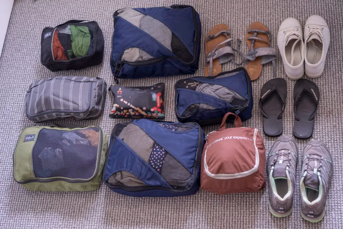 Everything I took on my trip to East Africa. A photo from above shows 6 green and black packing cubes, a small black zip up bags and brown toiletries bag - all filled - along with 4 pairs of shoes.