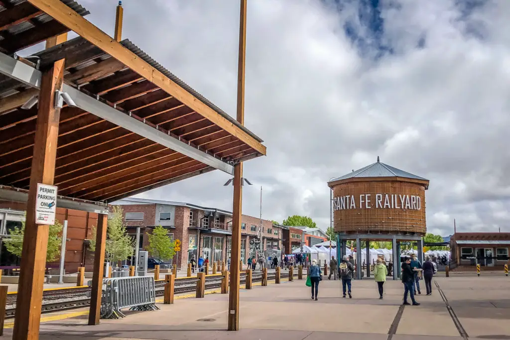 The Santa Fe Railyard area with people walking around, an old water tower with the text 