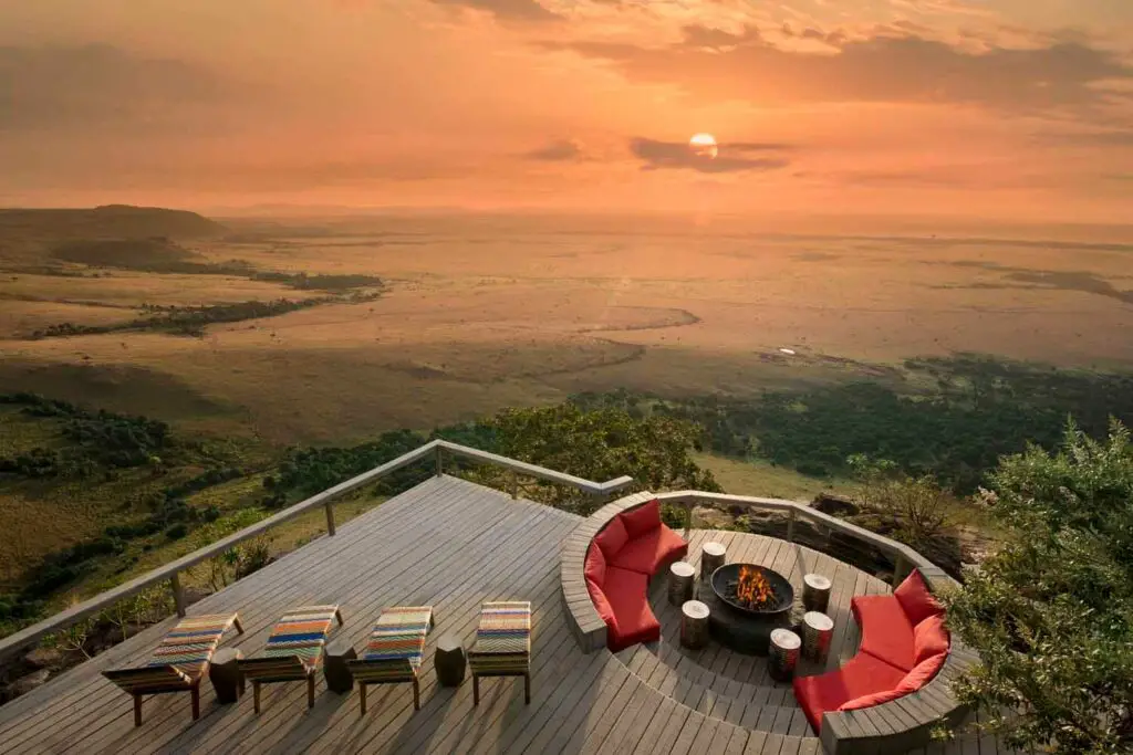 Angama Mara - one of the luxury hotels to stay near Maasai Mara on your Kenya itinerary. Four sun beds and a sunken lounge on a deck overlooking Maasai Mara National Reserve.