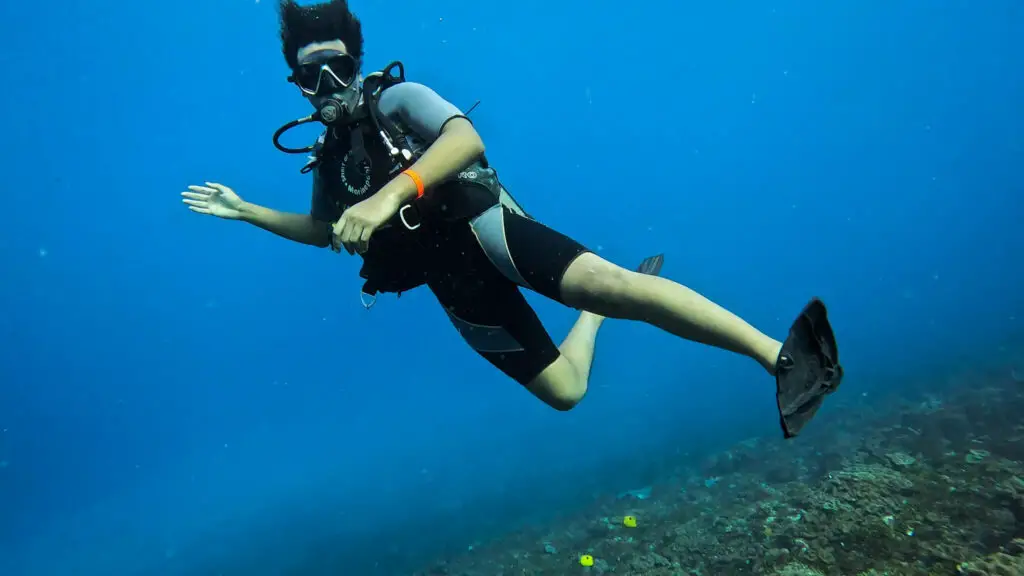 A person in scuba diving gear underneath the water - scuba diving is a great thing to do in Kenya at one of the many coastal towns and resorts