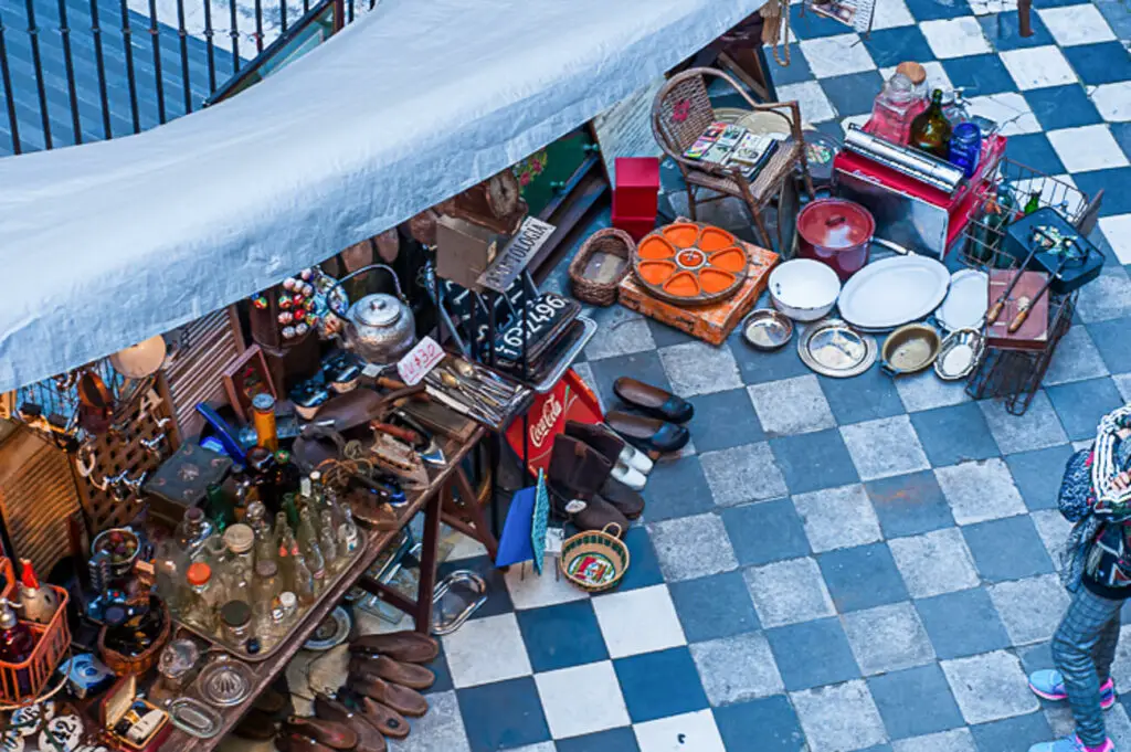 Looking down on to a shop full of antiques and second-hand goods. The floor is black and white checkered.