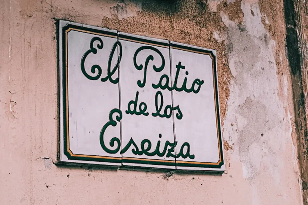 A sign on a crumbling facade says El Patio de los Eseiza - it's a sign on a street in Buenos Aires, Argentina
