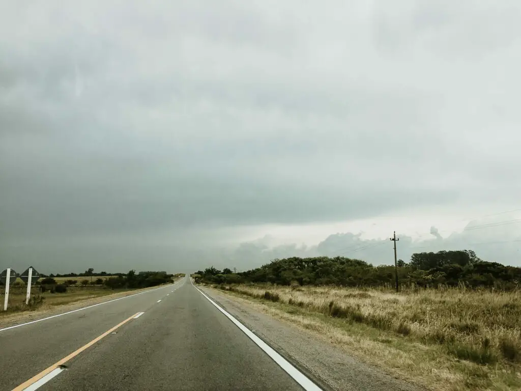 A road stretches into the distance under a cloudy sky in Uruguay