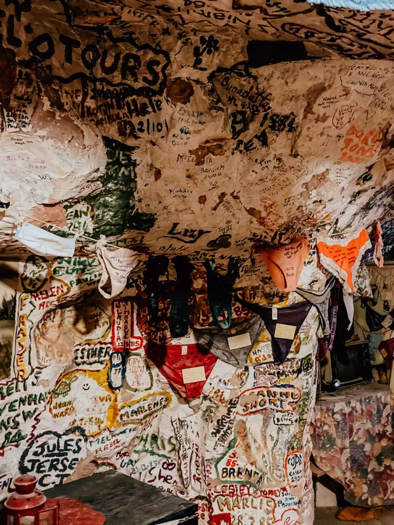 The inside of eccentric Crocodile Harry's in Coober Pedy shows graffiti and handwritten notes on the walls, along with women's underwear strung up.