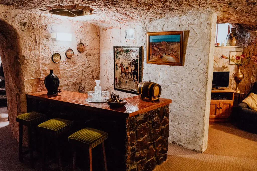 The inside of Faye's Underground Home in Coober Pedy shows a bar in the underground house. The design is 70s style. The home is one of the beset Coober Pedy attractions to visit in the town.