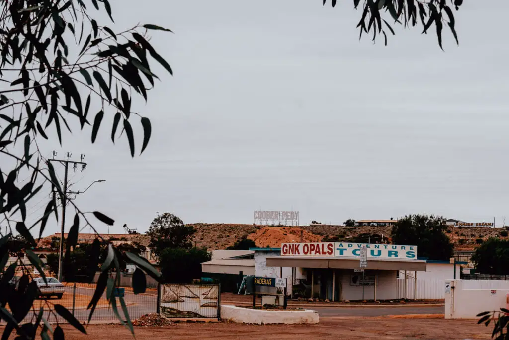 A white opal store is framed by a tree in Coober Pedy. Shopping for opals is one of the most popular things. todo in Coober Pedy, South Australia