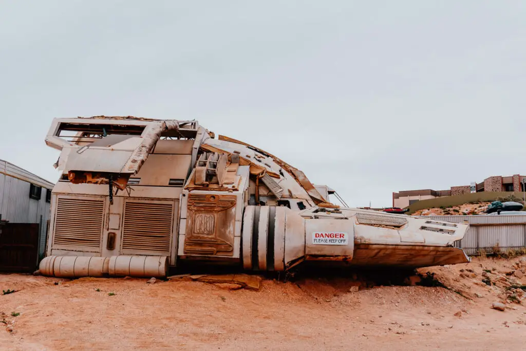 A spaceship sits in the dirt on the main street of Coober Pedy. The spaceship is a prop from the film Pitch Black, which was filmed in Coober Pedy