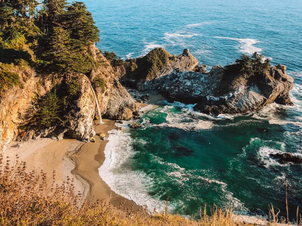 A small waterfall called McWay Falls, flows into the ocean along the Pacific Coast Highway