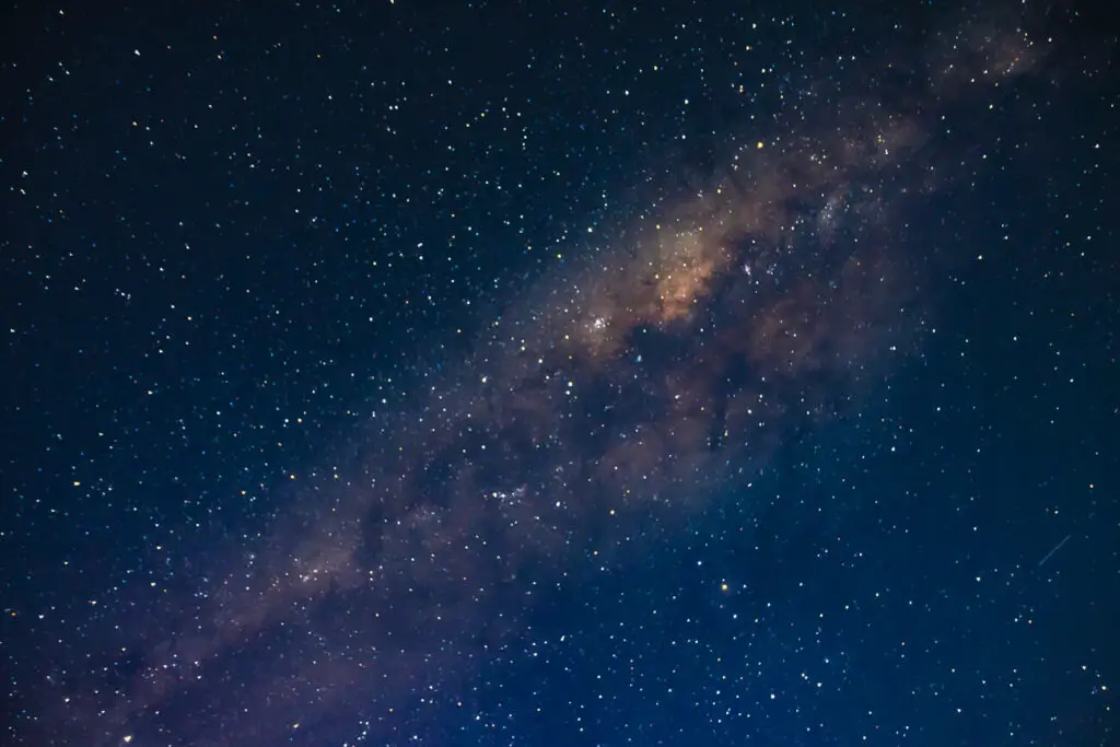 A star-filled night sky featuring the Milky Way with shades of blue and purple against the dark vastness of space.