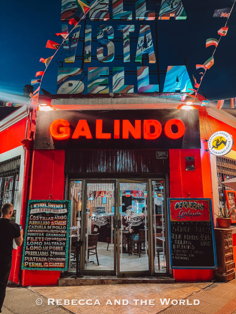 The brightly lit exterior of Galindo restaurant in Bellavista features bold red signage and colorful decor at night, a popular local dining spot often featured in a Santiago itinerary for those spending 2 days in Santiago.
