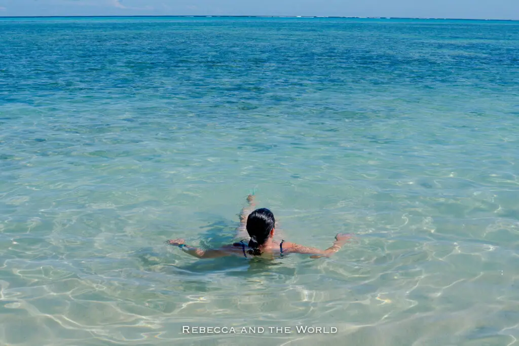 A person - the author of this article - swims in the crystal-clear, shallow waters near Exmouth, Western Australia.
