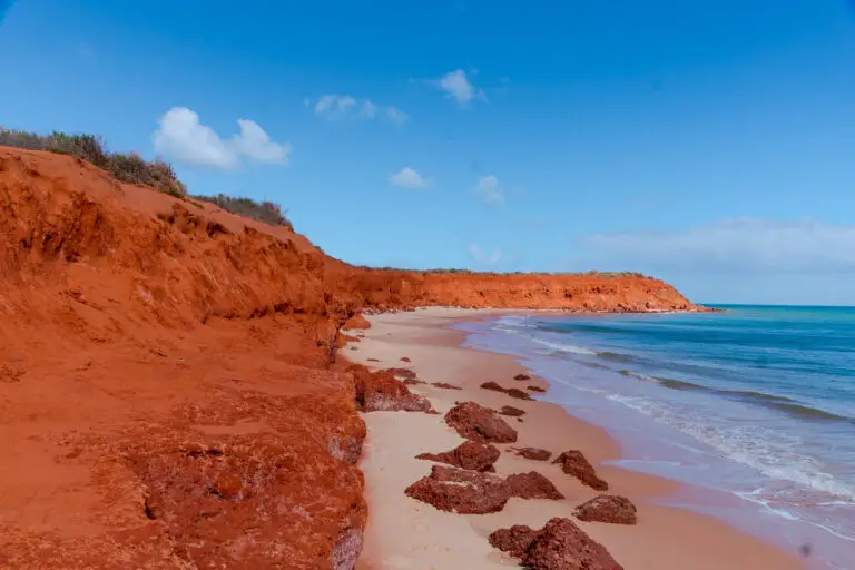 The vivid red cliffs of coastal Western Australia, meet the white sandy beach and turquoise waters of the Indian Ocean. The striking contrast of colours is a signature feature of WA's coastal landscape.