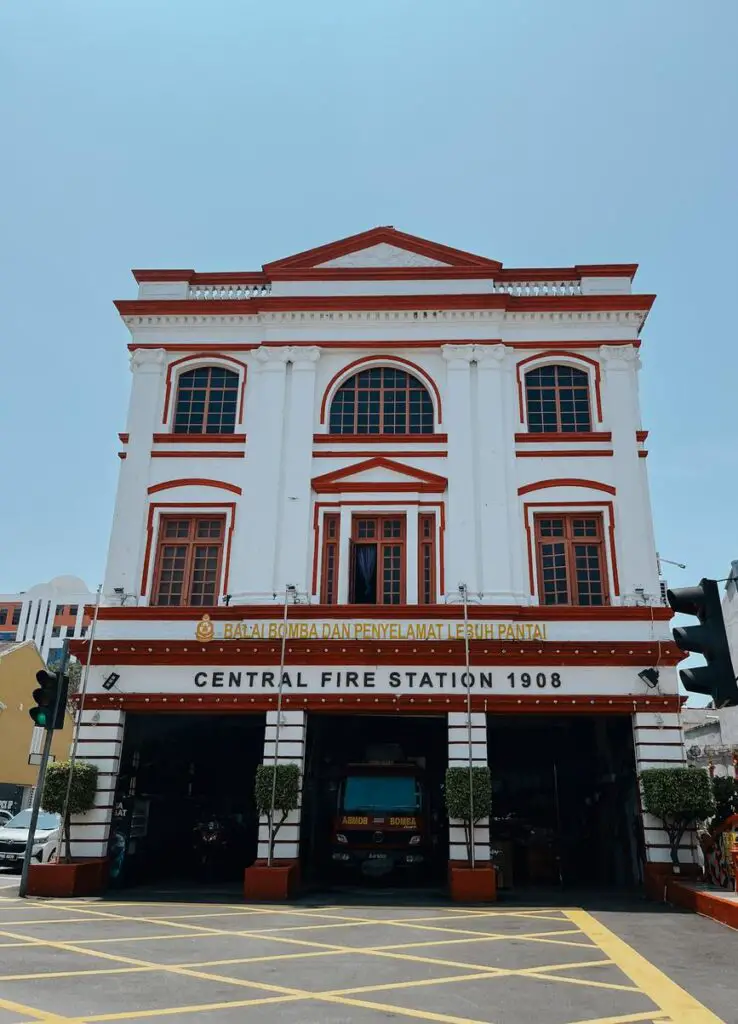 Front view of the Central Fire Station in Penang, a colonial-era white building with red trim and arched windows, established in 1908.