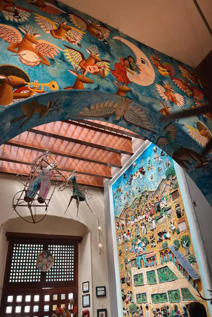 Bright and whimsical folk art mural featuring winged animals and musicians, located inside Casa de los Venados, a Valladolid highlight.