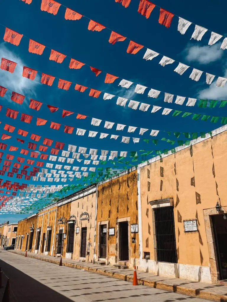 Vibrant papel picado banners hang above the ochre streets of Izamal, known as the Yellow City.