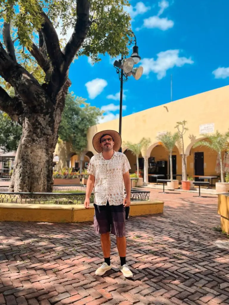 Man - our guide on a free walking tour of Merida - standing in a leafy plaza in Merida, a charming colonial city.