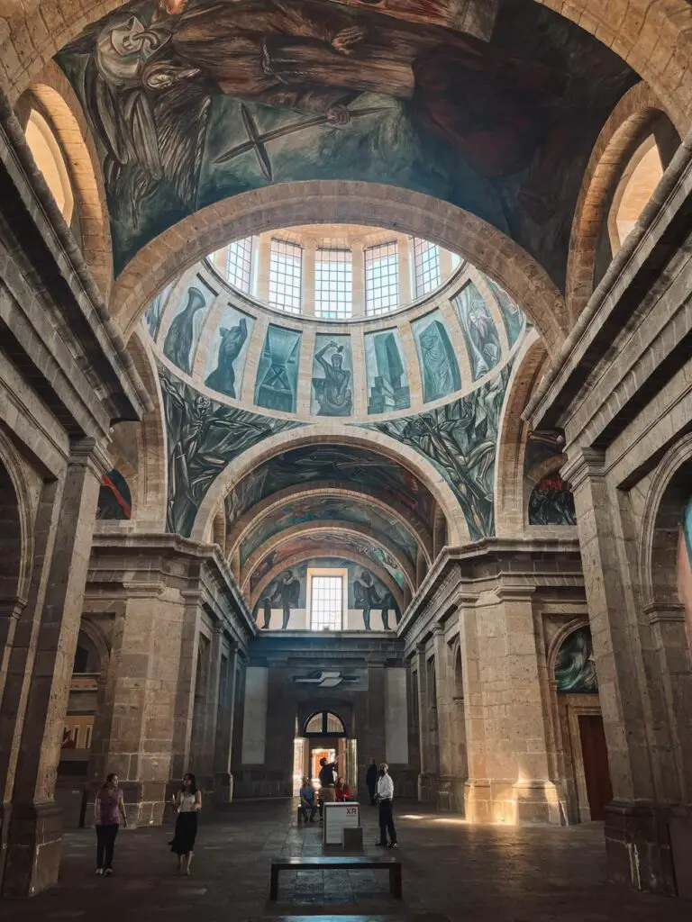 Interior of the Cabañas Cultural Institute in Guadalajara, showcasing its grand arched ceilings and José Clemente Orozco's iconic frescoes, a must-see cultural stop in the city.