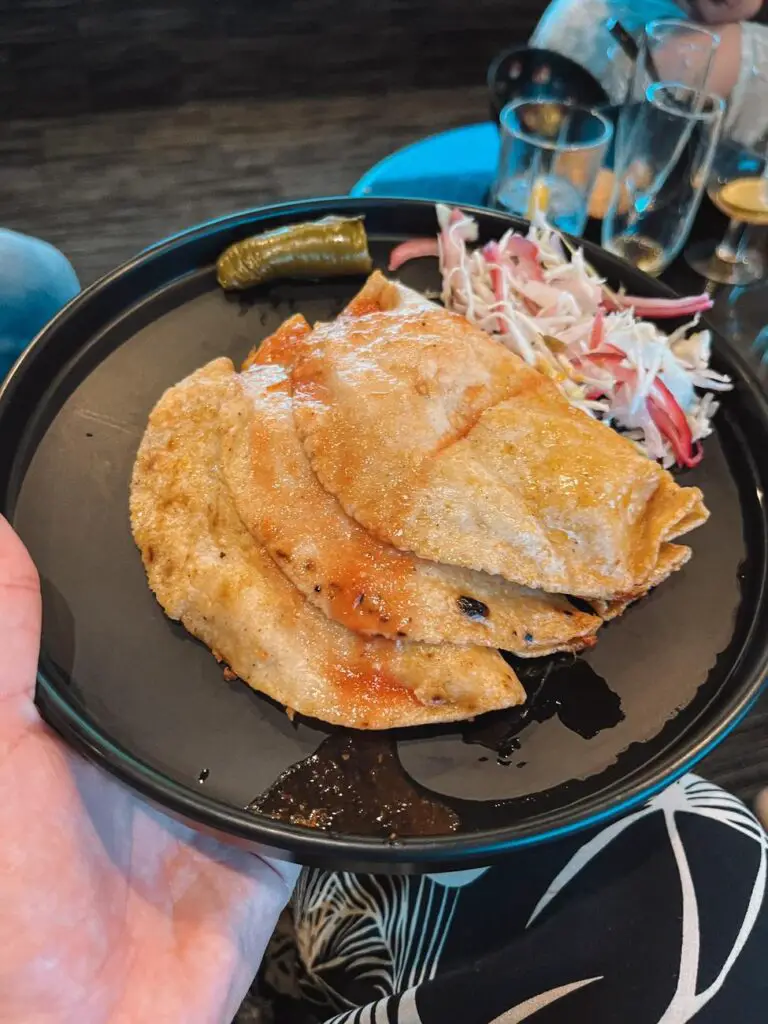 A plate of quesadillas with salsa and pickled vegetables, served on the Jose Cuervo Express train.