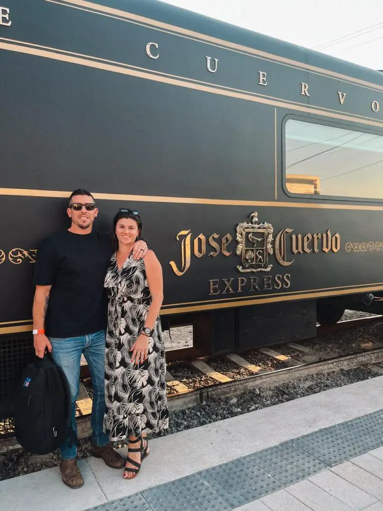 A couple - the author and her husband - posing in front of the elegant black and gold Jose Cuervo Express train before boarding.