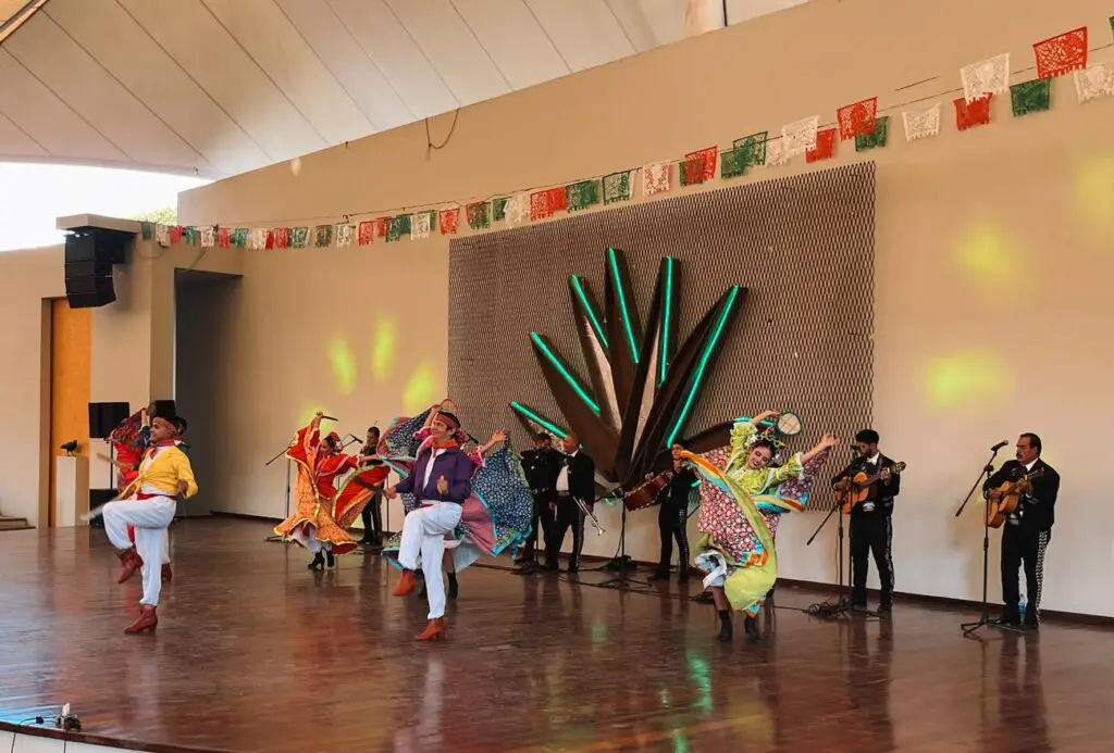 A live folkloric dance performance with mariachi music at the Jose Cuervo Express event, featuring colorful costumes and vibrant stage lighting.