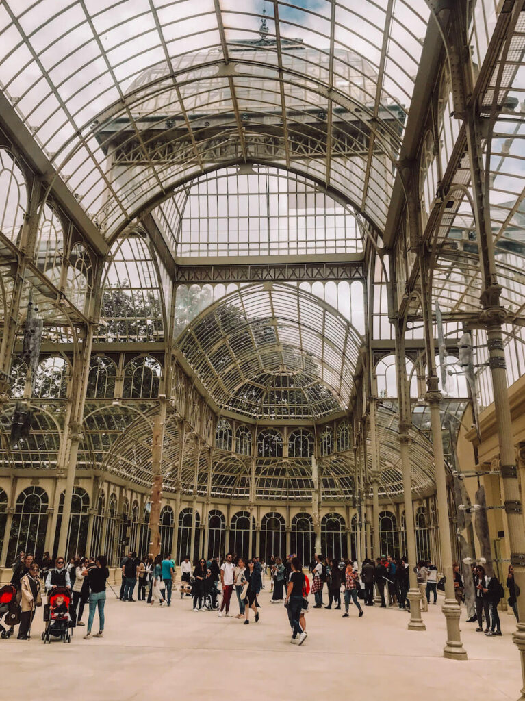 Interior of the Palacio de Cristal in Retiro Park, a striking glass pavilion often featured on a 2-day Madrid itinerary for first-time visitors.