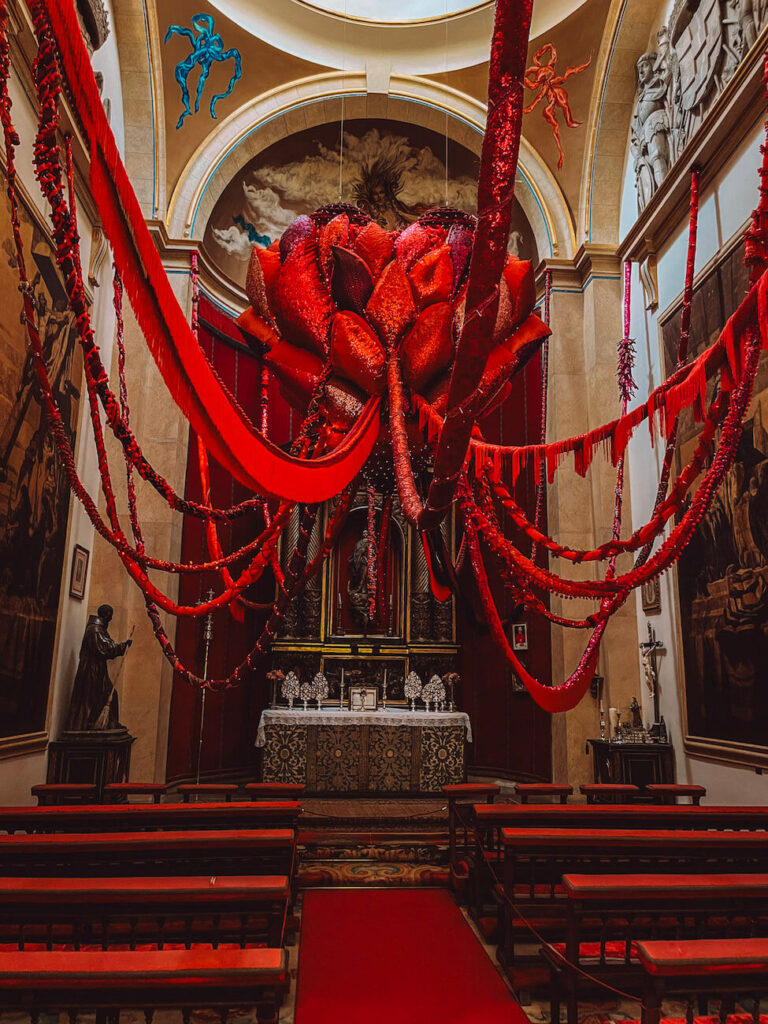 Chapel interior in Liria Palace in Madrid decorated with a dramatic red contemporary art installation above the altar – a surprising cultural experience for a Madrid itinerary.