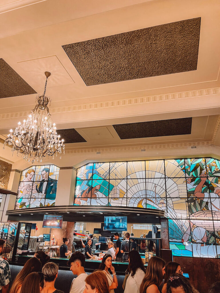 Inside McDonald’s Imperial in Porto, with chandeliers and stained glass windows above a busy counter – a unique fast food experience for your 2 days in Porto.
