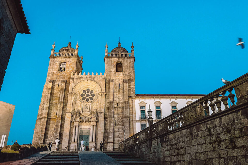 Façade of Porto Cathedral (Sé do Porto) under a clear blue sky, with twin towers and a large rose window – a historic site to include in your 2-day Porto itinerary.