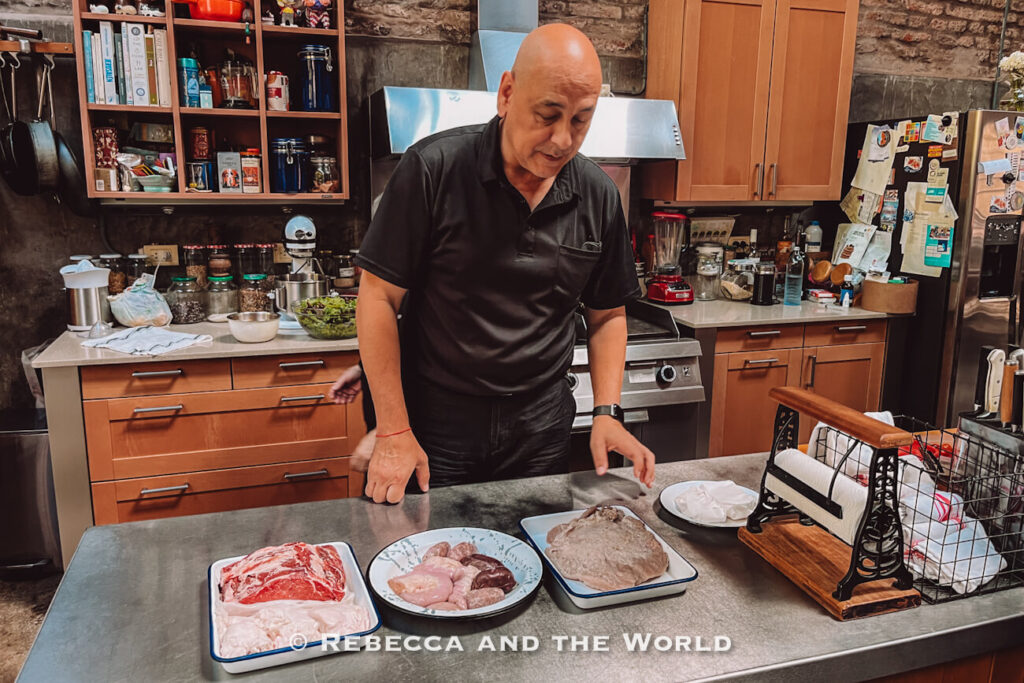 Host preparing different cuts of meat in the kitchen before cooking at Asado Adventure, giving insight into an Argentine asado experience in Buenos Aires.