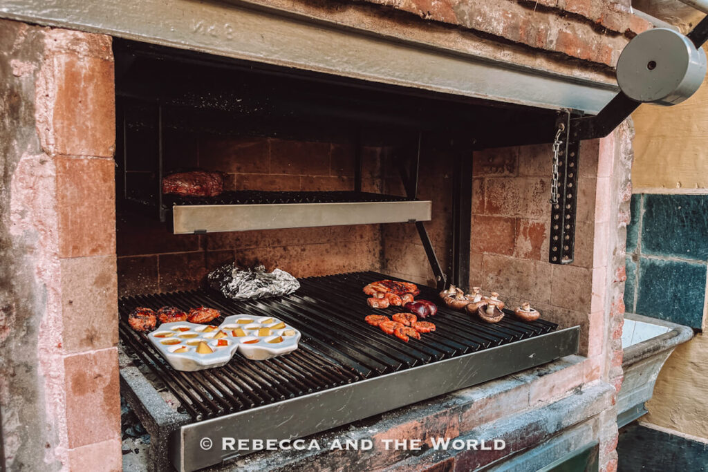 Meat, chorizo and vegetables cooking over the grill at Asado Adventure, a classic scene from an Argentine barbecue in Buenos Aires.